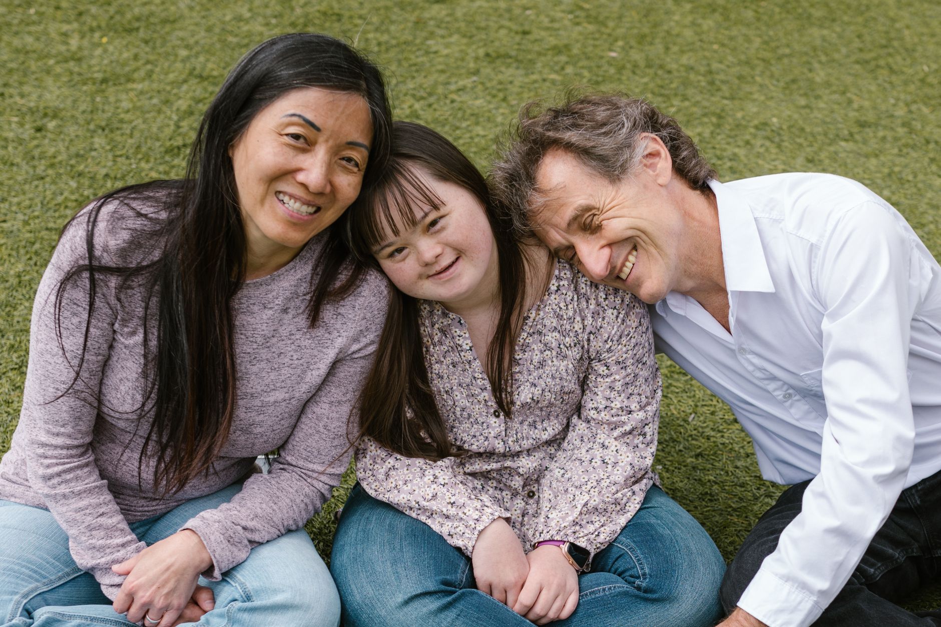 a happy family sitting on the grass